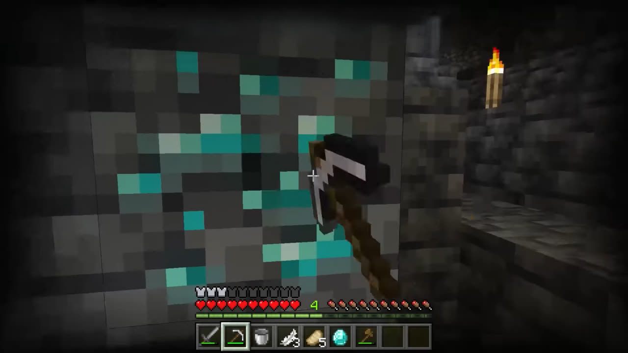 A player mining diamond ore with an iron pickaxe by torchlight